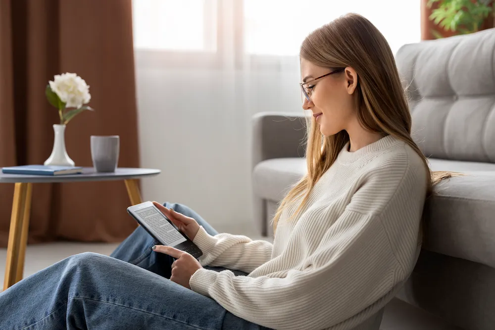 Femme qui lit sur sa tablette pour comparer les mutuelles qui remboursent la sophrologie